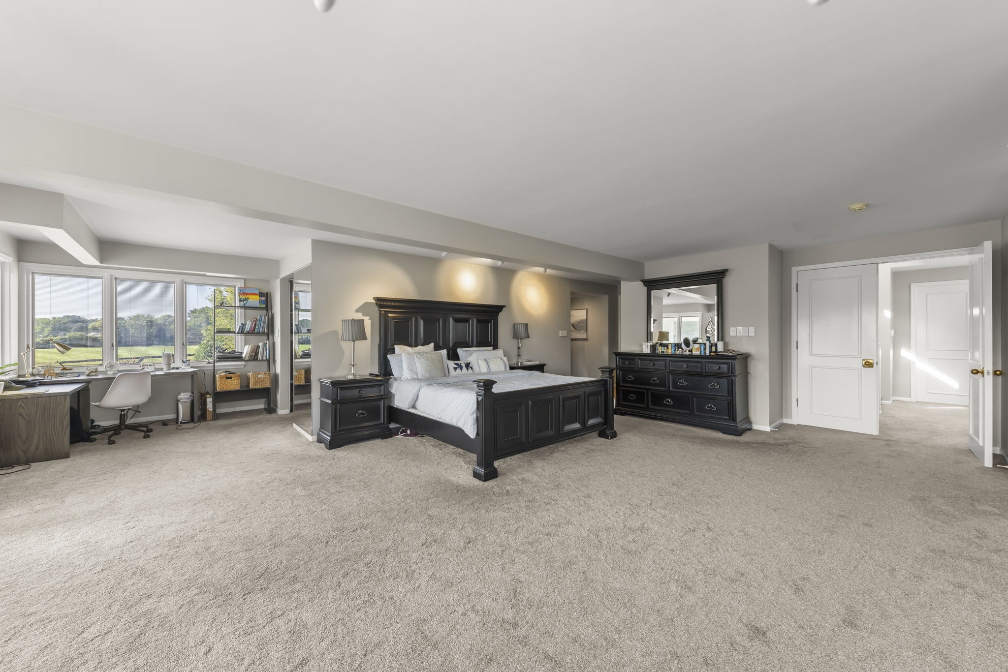 Naperville luxury home primary spa bath at 23W735 Hobson Rd featuring elevated sunken black marble whirlpool jacuzzi tub, architectural lattice glass wall, and skylights